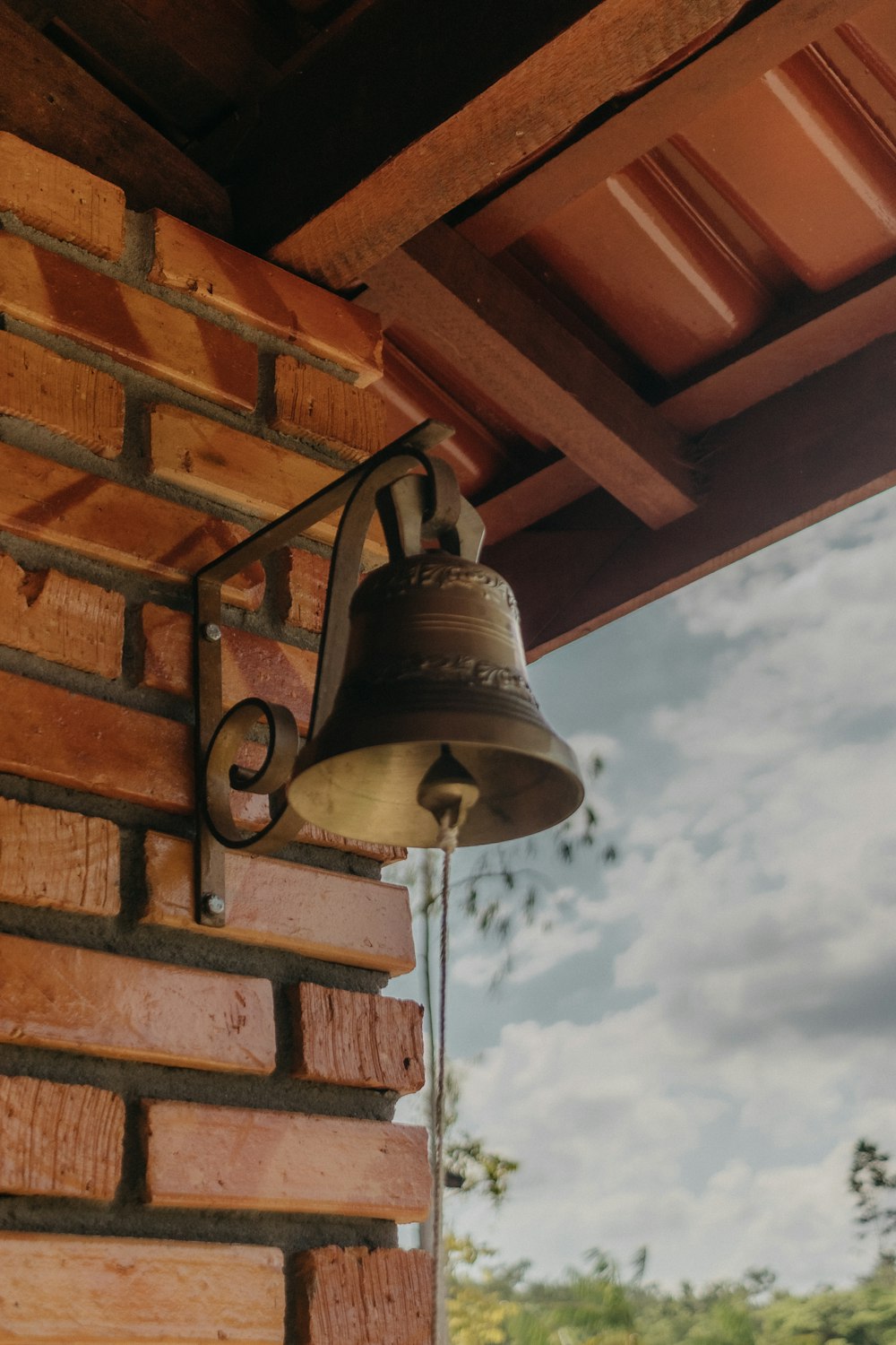 a bell hanging from the side of a brick building