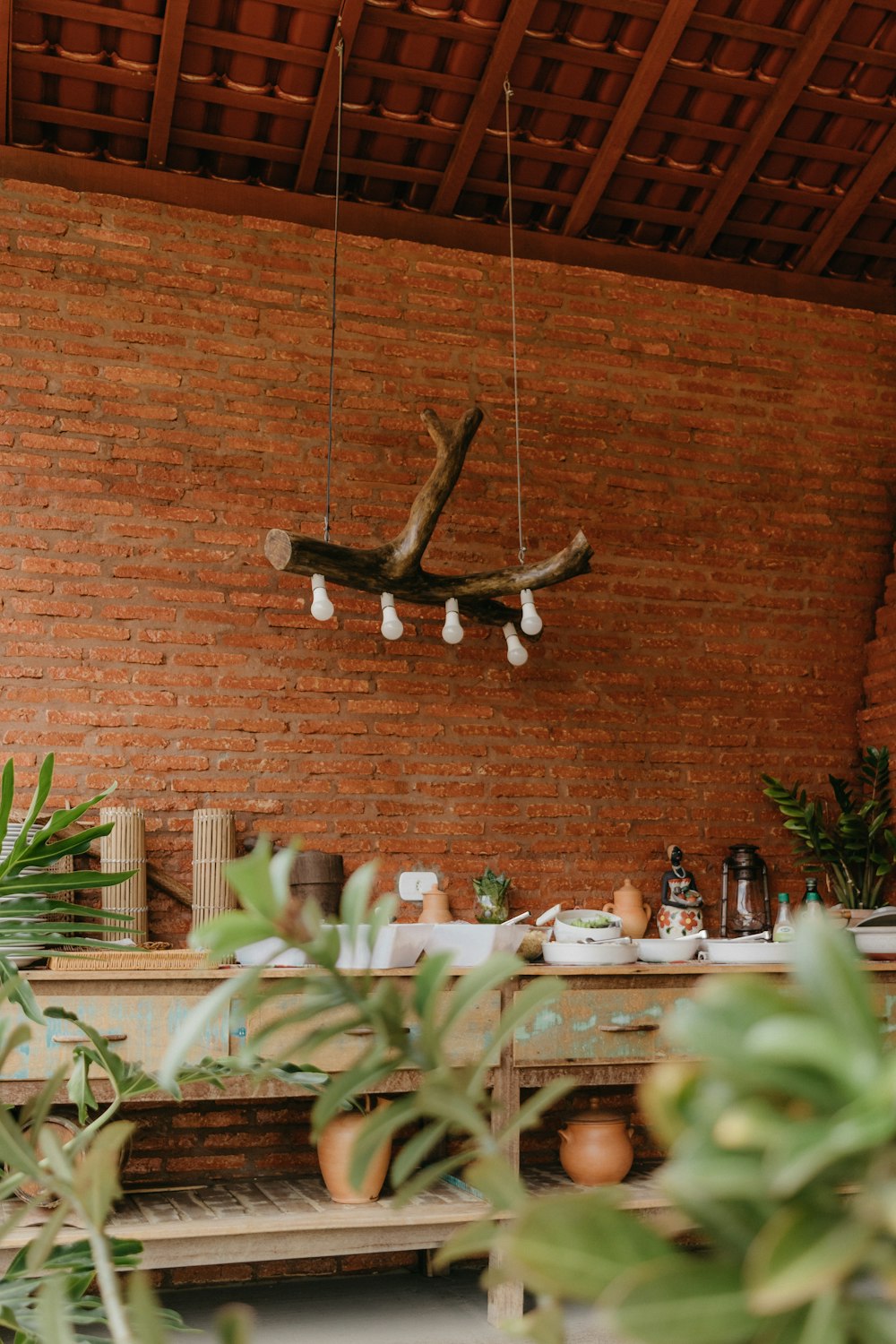 a room with a brick wall and a plant hanging from the ceiling