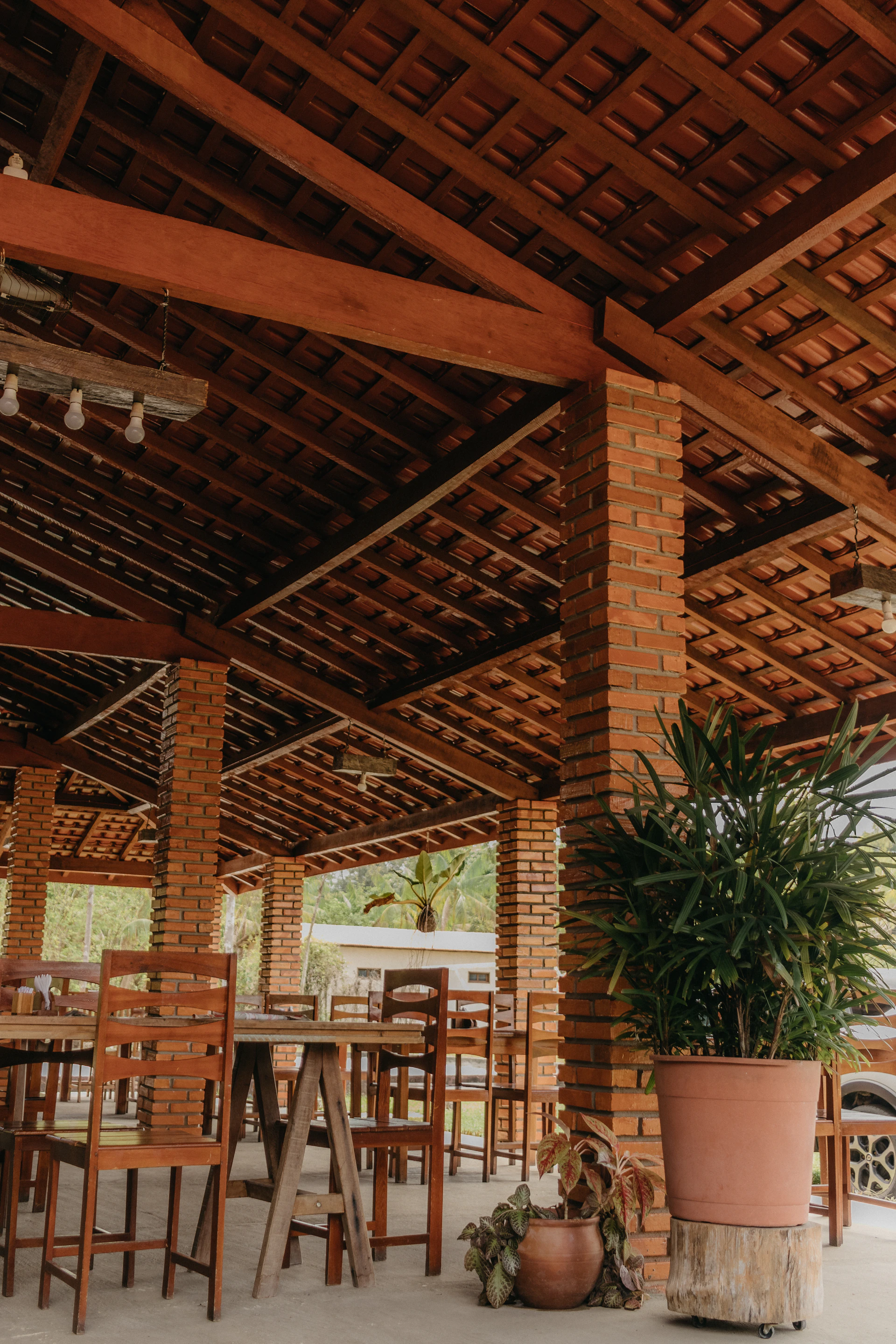 A cozy quincho area set for a family gathering, with wooden tables and a barbecue grill ready for use.