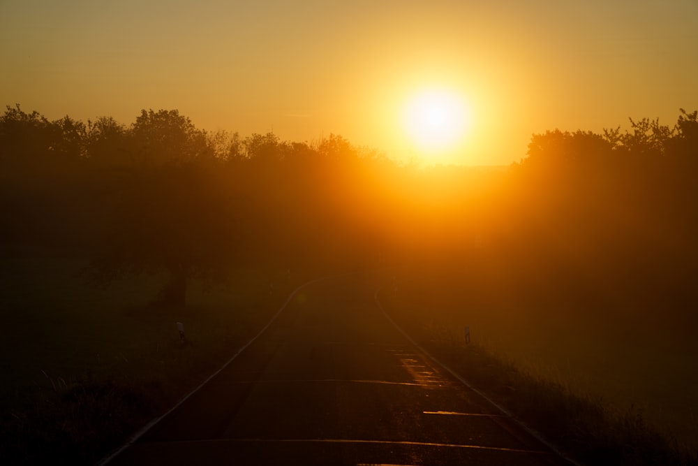 the sun is setting over a train track