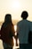 A joyful couple holding hands, enjoying a beautiful sunset.