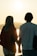 A happy couple enjoying a sunset together, smiling and holding hands.
