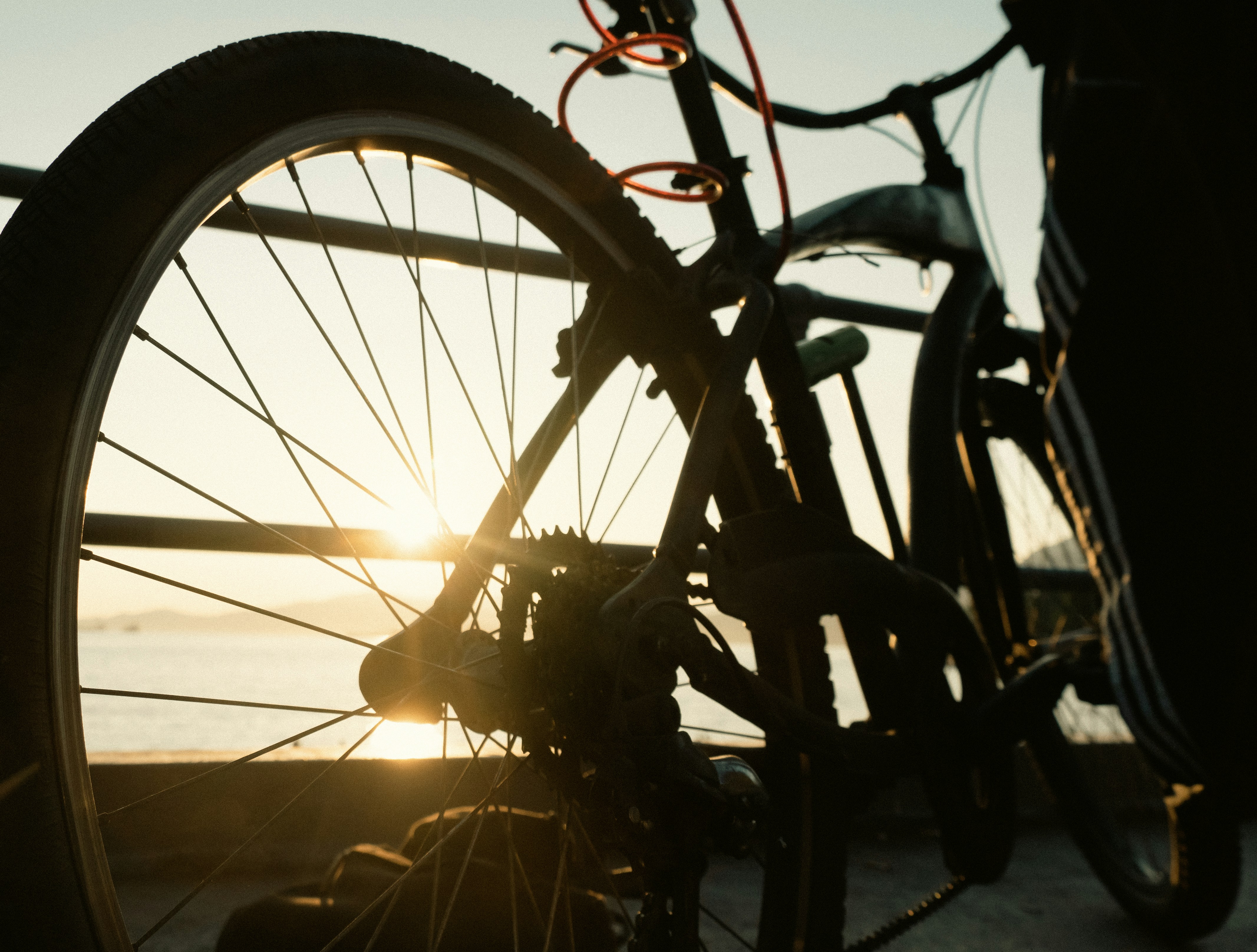 a close up of a bike with the sun setting in the background