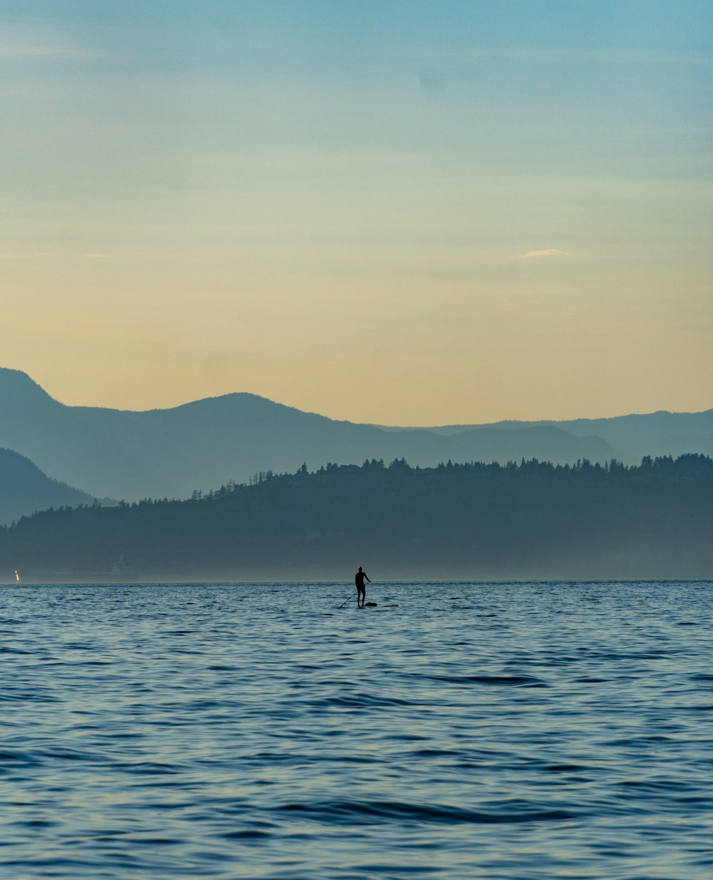 a person standing on a surfboard in the middle of the ocean