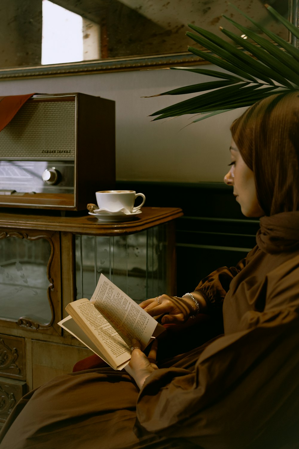 une femme assise sur une chaise lisant un livre