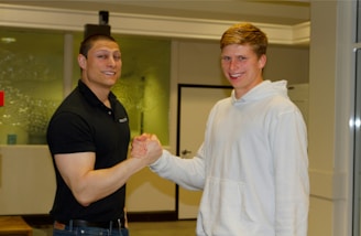 A homeowner shaking hands with a real estate investor in a modern living room.