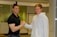 A happy customer shaking hands with a professional technician in uniform.
