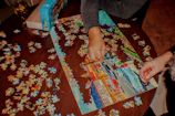 Close-up of hands assembling a colorful puzzle featuring Caribbean landmarks and wildlife.
