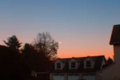 Completed modern roof installation on a suburban home at sunset.