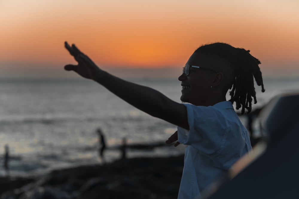 a person with dreadlocks standing on a beach