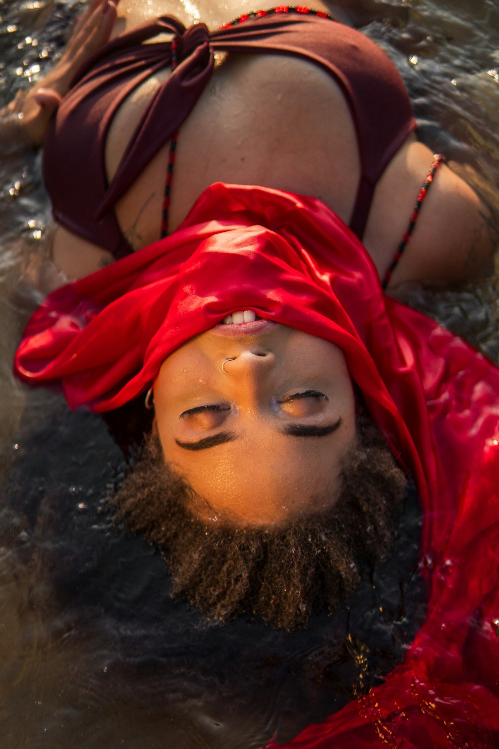 a woman in a red dress is floating in the water