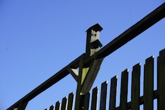 Friendly fence installer talking to a homeowner next to a freshly built wood privacy fence