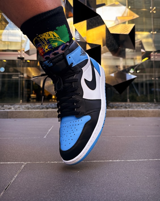 Close-up of a person wearing a vibrant Nike sneaker on a city street