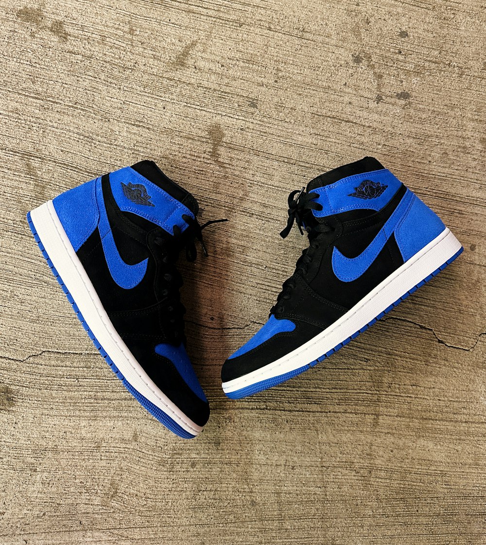 a pair of blue and black sneakers on a wooden floor