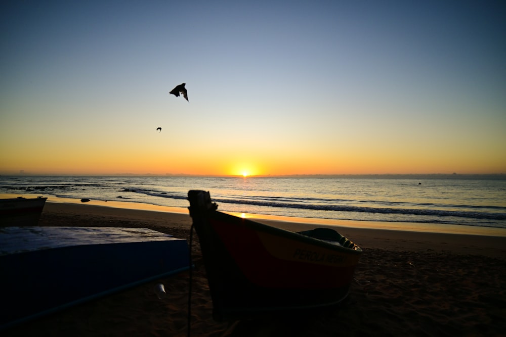 a boat sitting on top of a beach next to the ocean