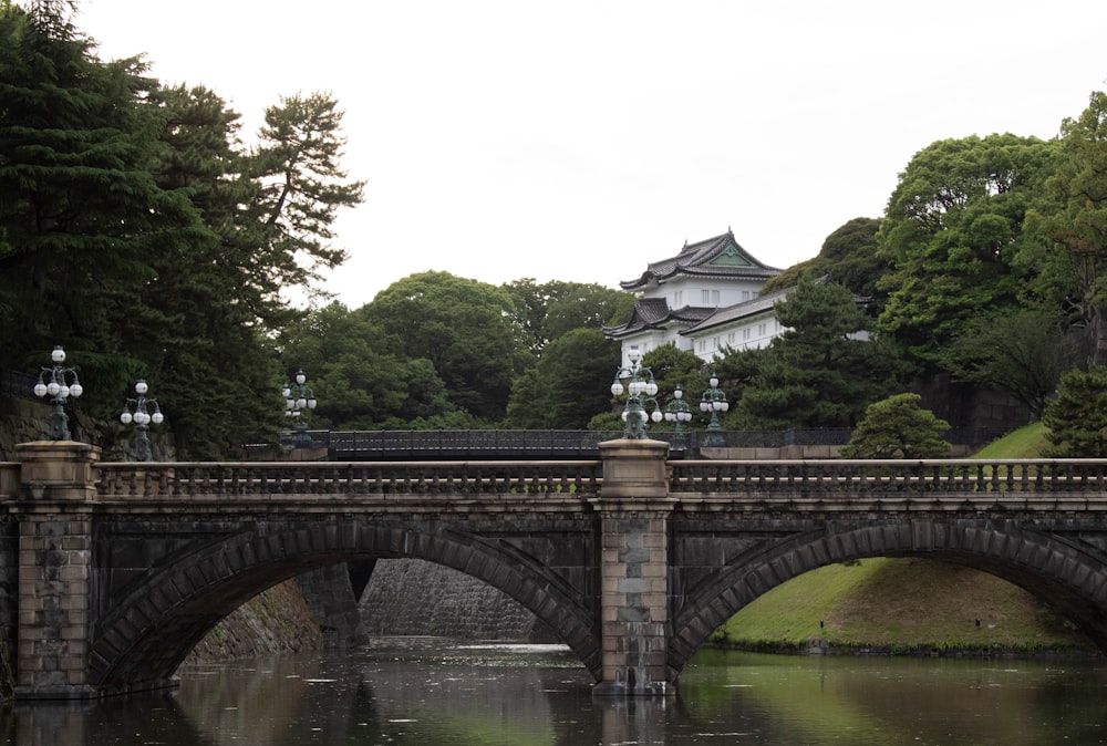 a bridge over a body of water with a building in the background