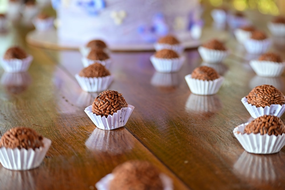 a table topped with lots of cupcakes on top of a wooden table