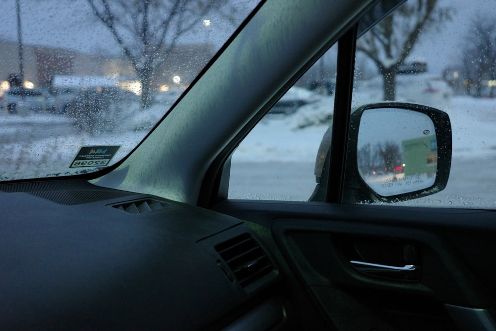 a car's side view mirror on a snowy day