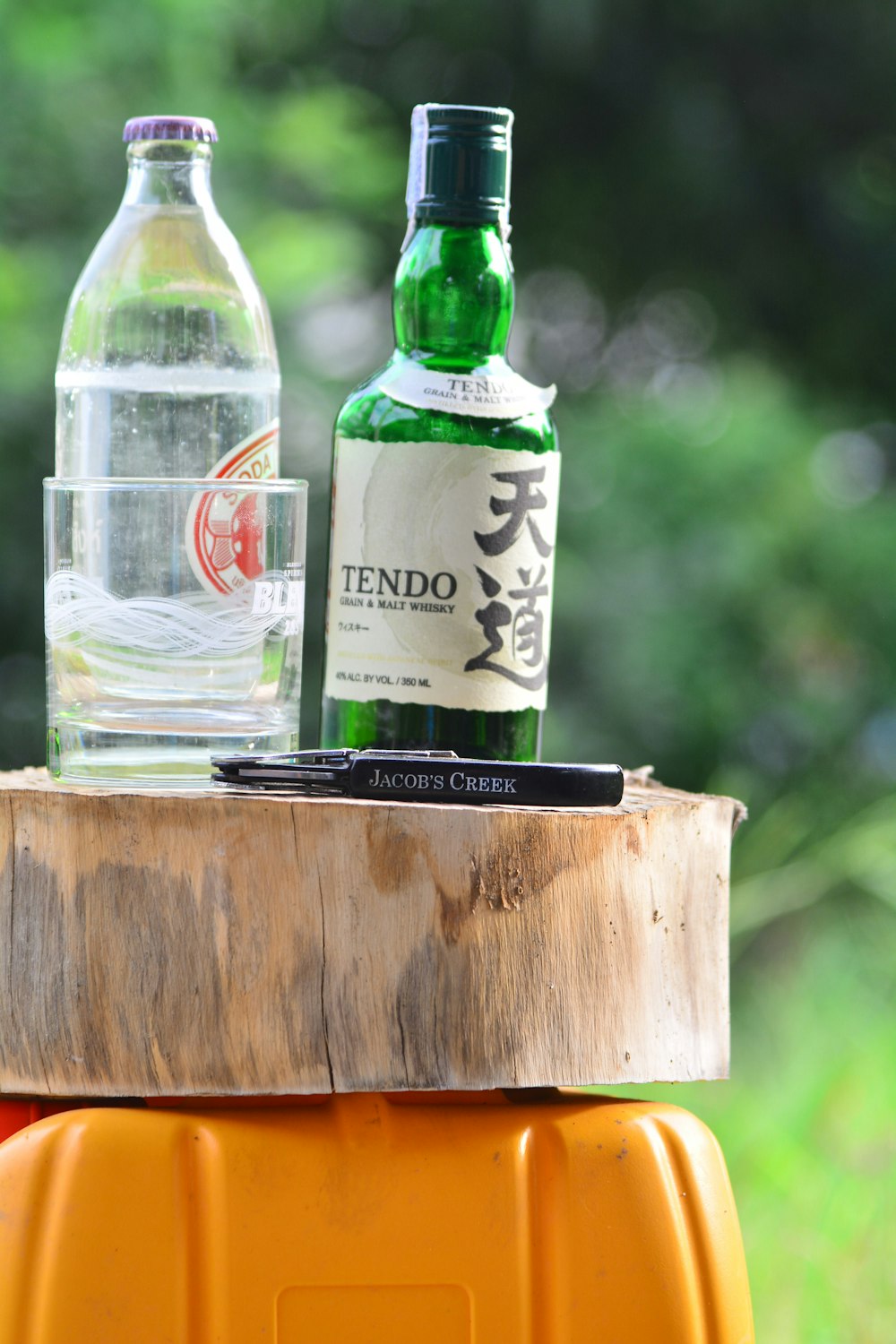 a bottle of water sitting on top of a wooden barrel