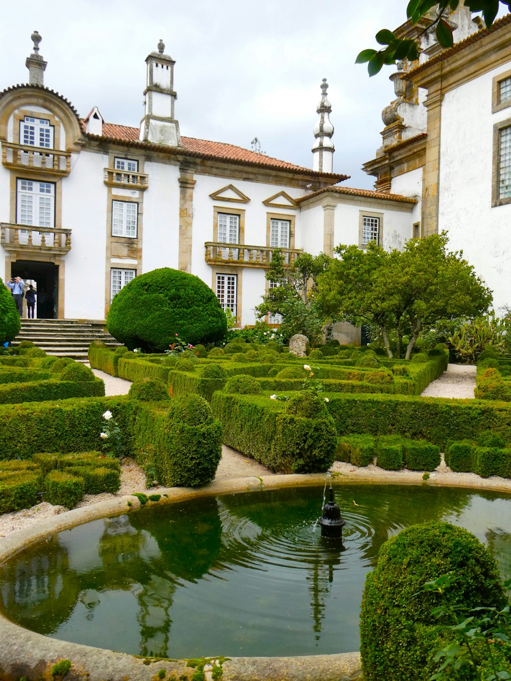 Un gran edificio blanco con una fuente frente a él