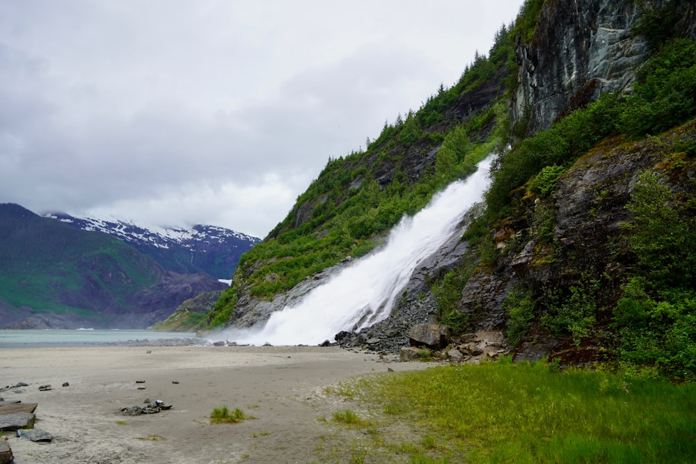 a waterfall is coming out of the side of a mountain