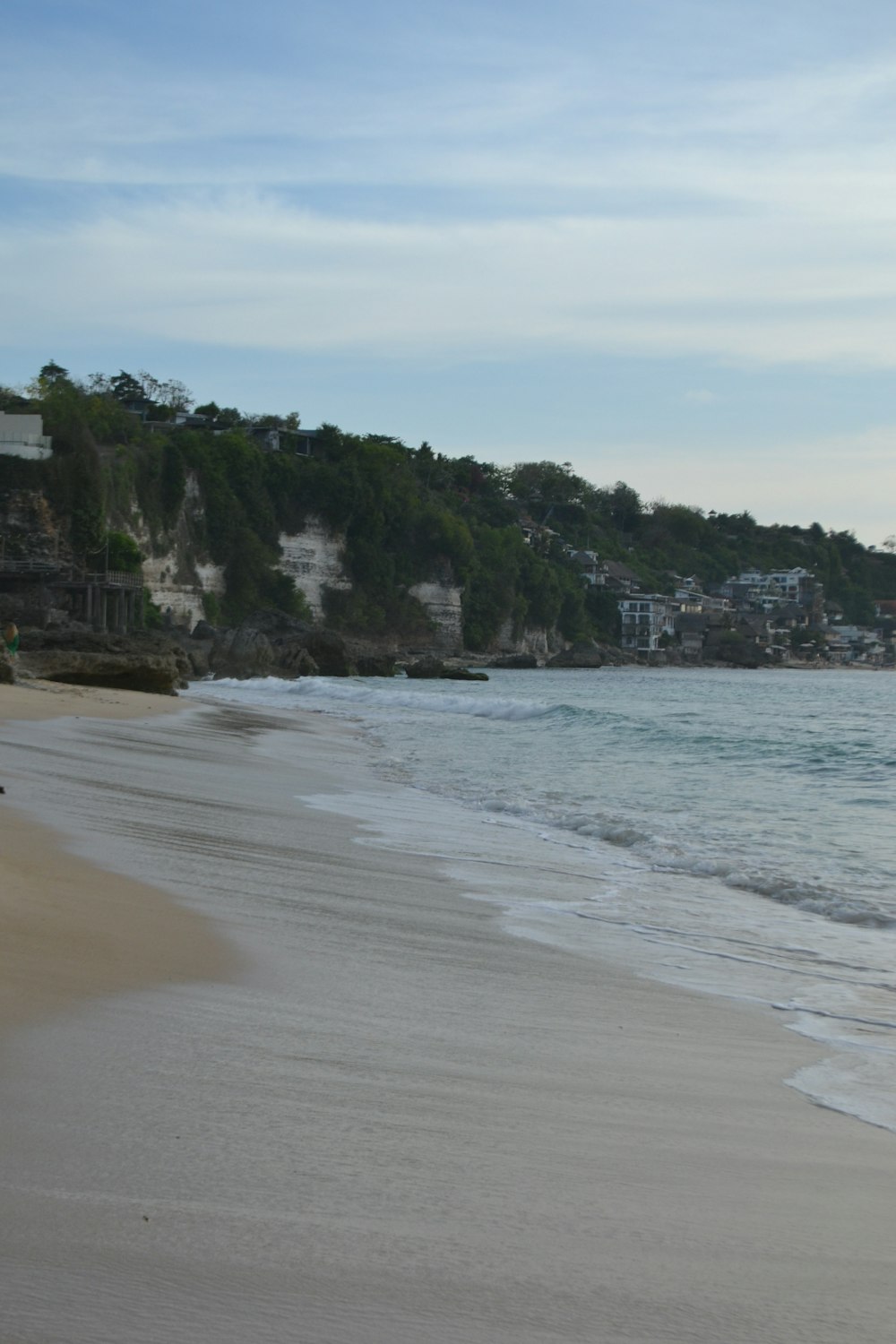 a sandy beach next to a body of water