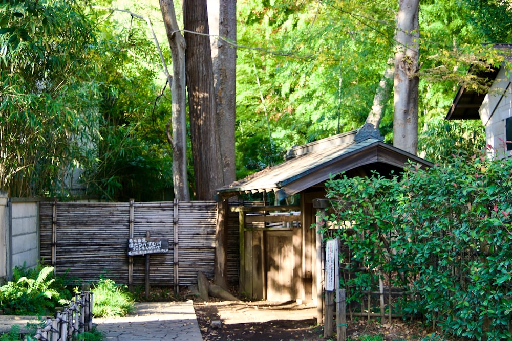 a small wooden outhouse in the middle of a wooded area
