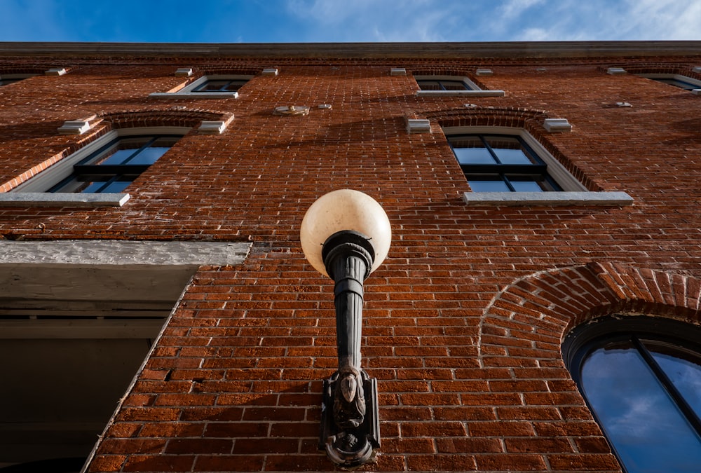 a street light on the side of a brick building