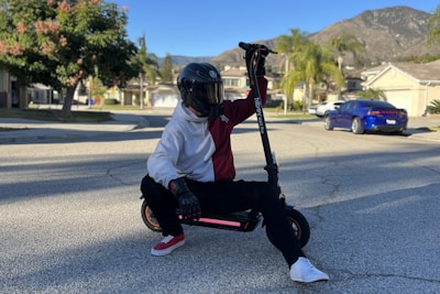 a person sitting on a scooter on the street
