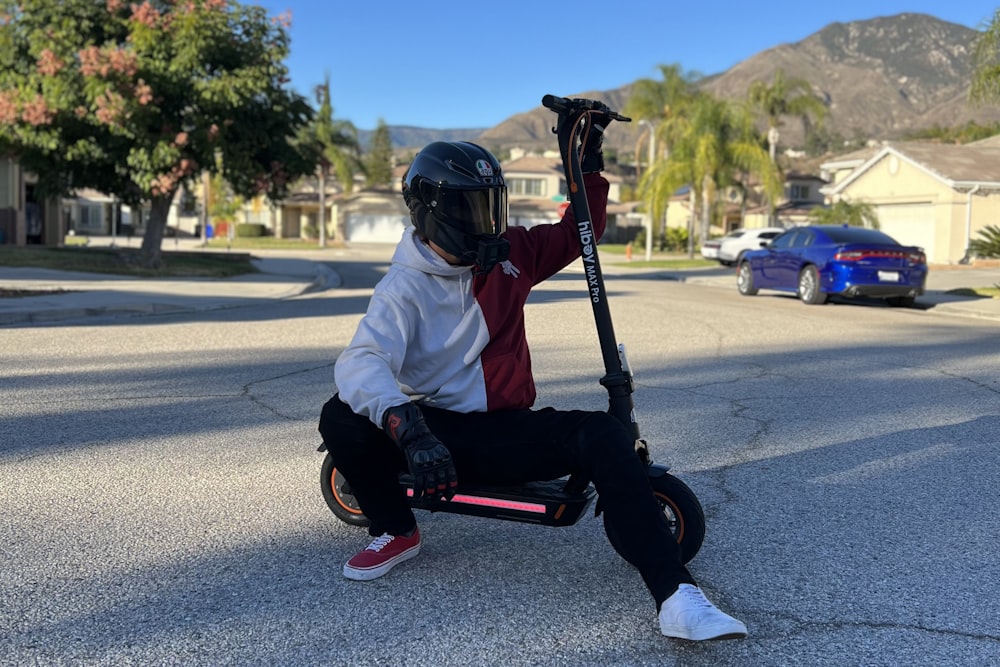 a person sitting on a scooter on the street