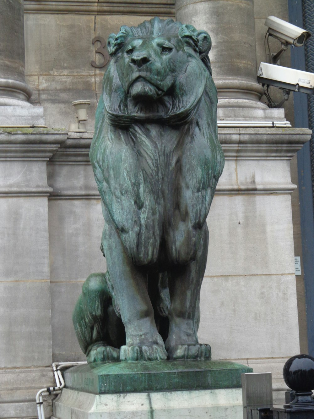 a statue of a lion on a pedestal in front of a building
