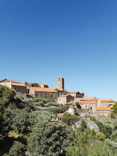 a small village on a hill with a clock tower