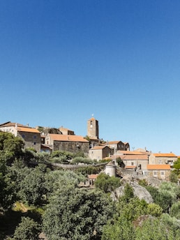 a small village on a hill with a clock tower