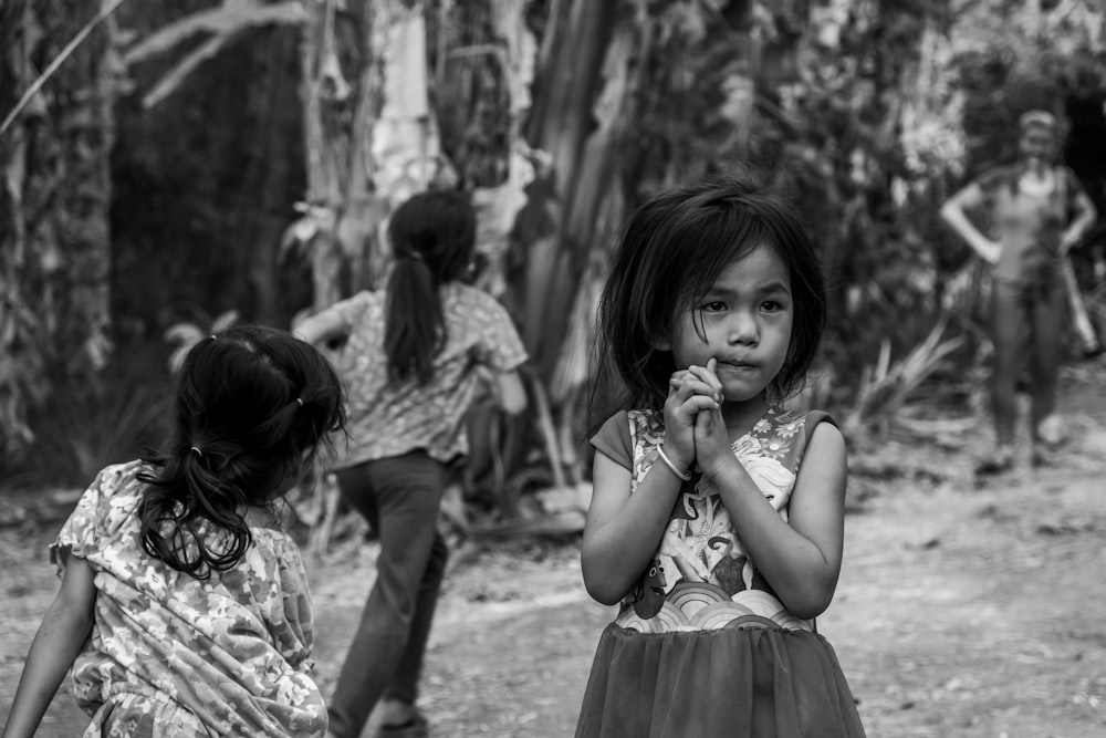 a black and white photo of a little girl eating something