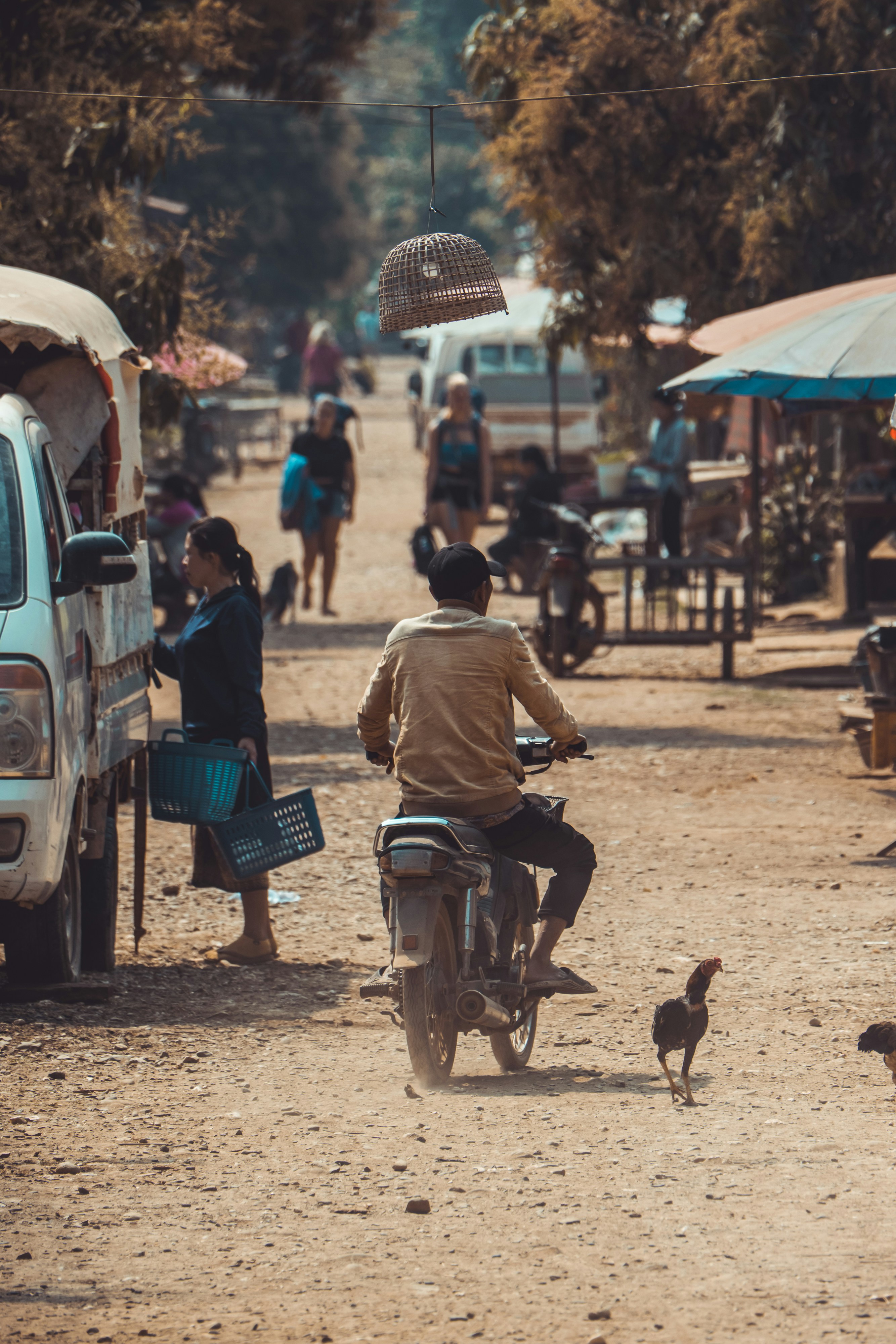 ein Mann, der mit einem Motorrad eine unbefestigte Straße hinunterfährt