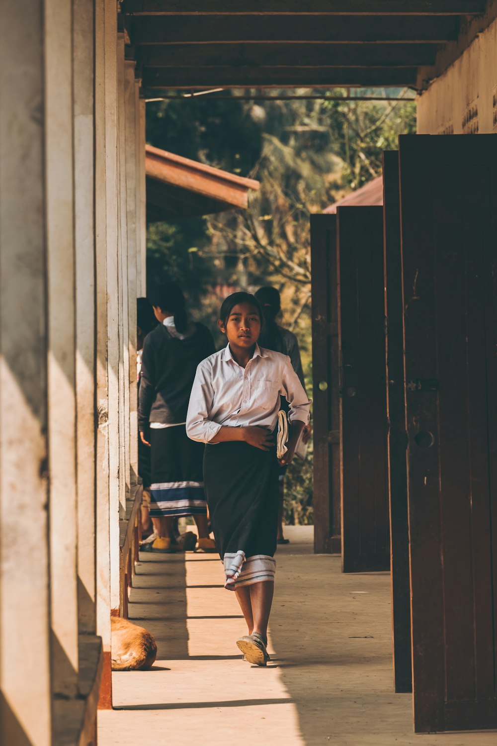 a woman walking down a sidewalk next to a building