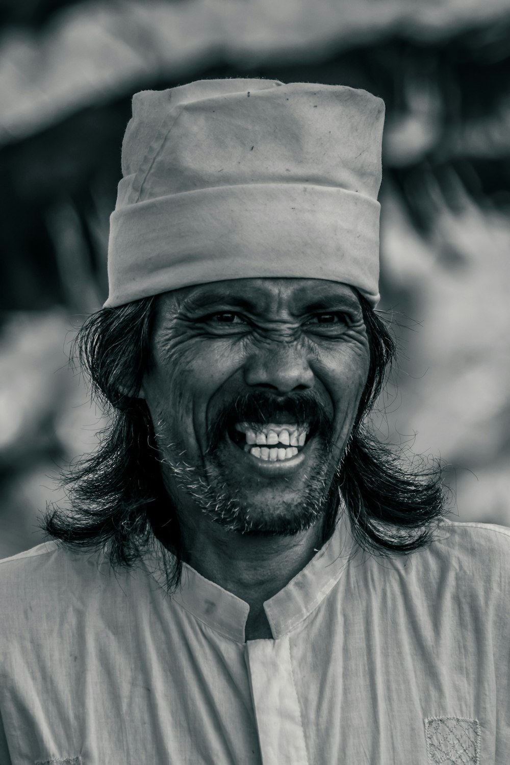 a black and white photo of a man wearing a hat