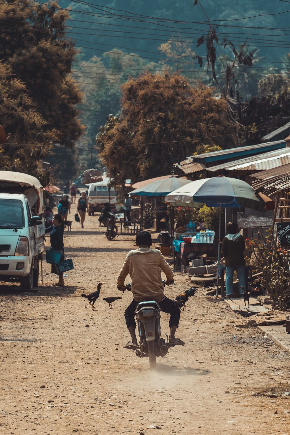 a man riding a bike down a dirt road