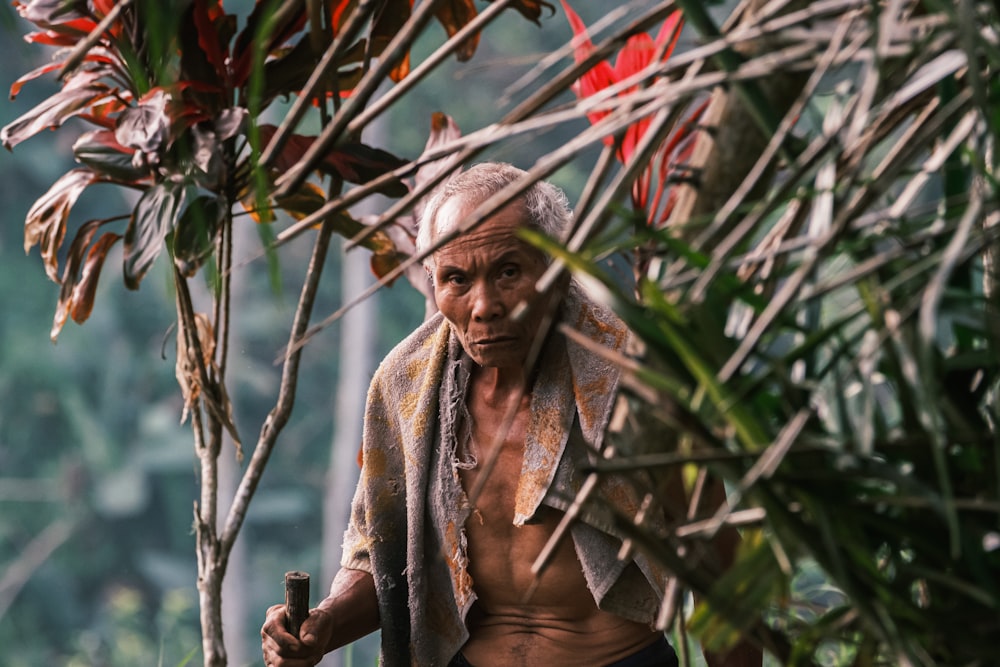 a man with a towel on his head walking through a jungle