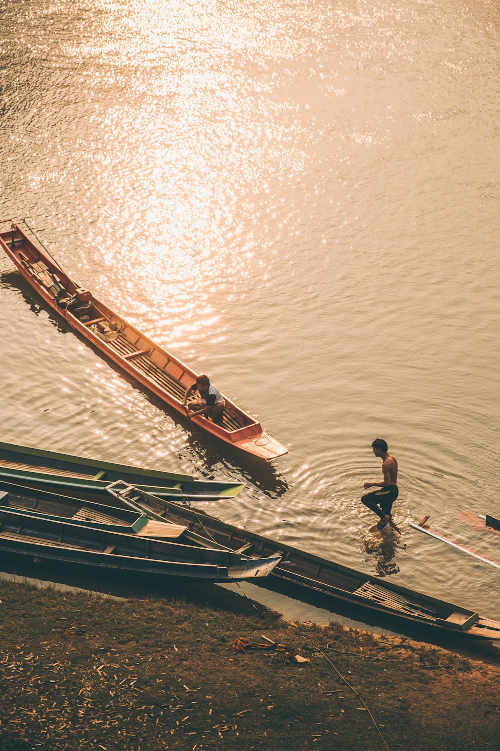 a man standing next to a boat on top of a body of water