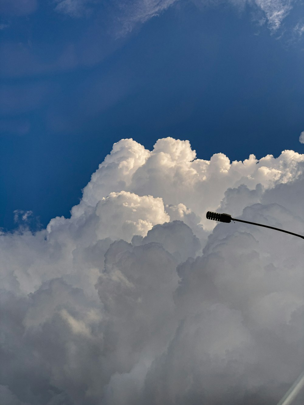 a street light in front of a cloud filled sky