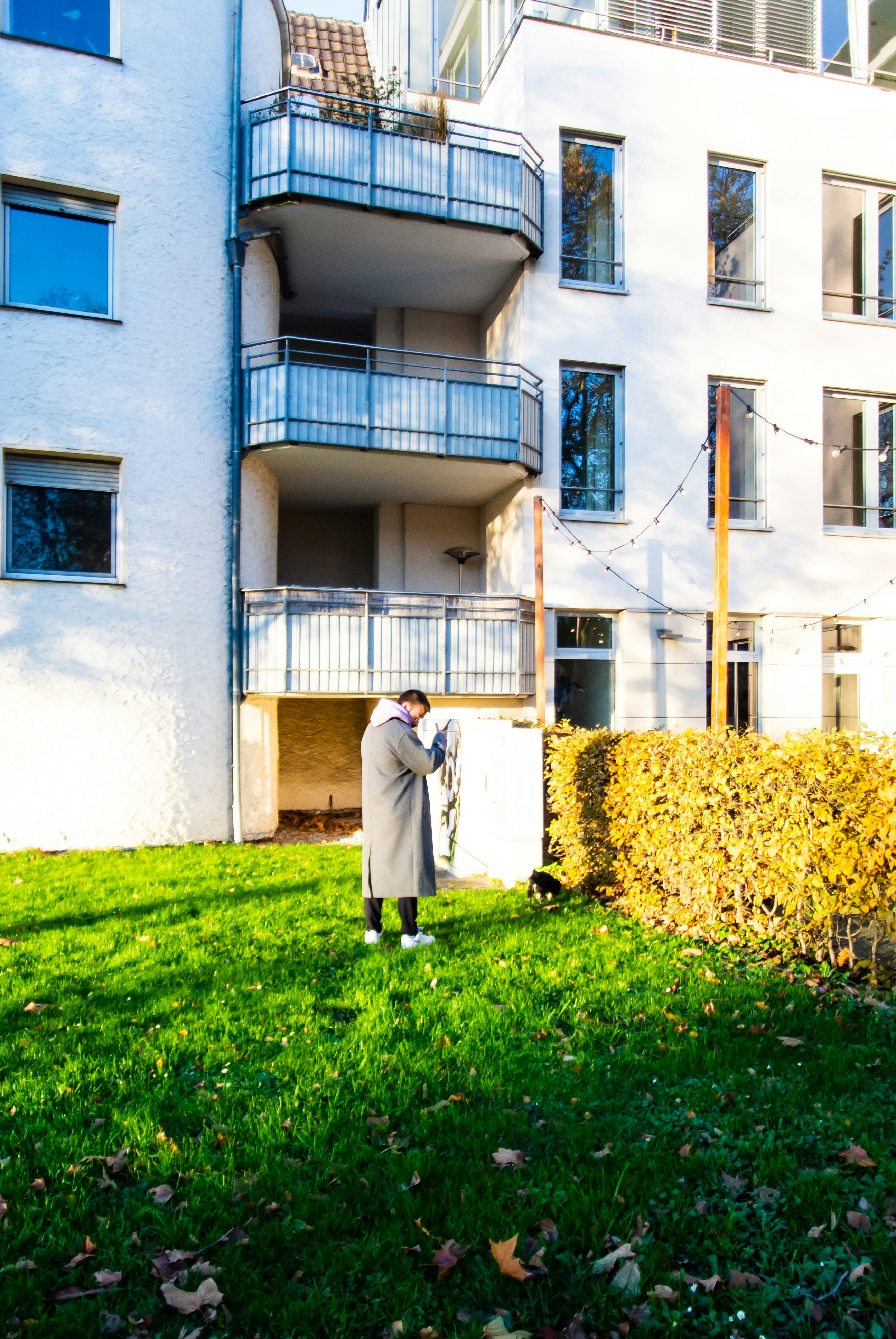 a man standing in the grass in front of a building