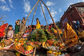 a group of people standing around a pile of fruit
