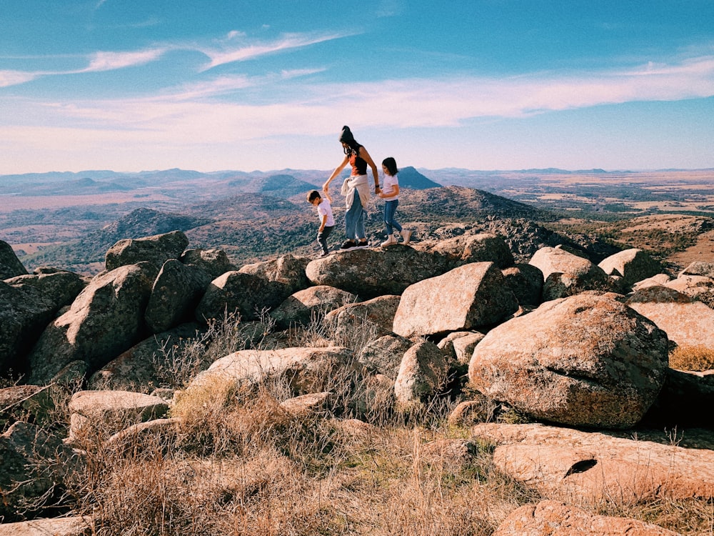 a group of people standing on top of a rocky hillside