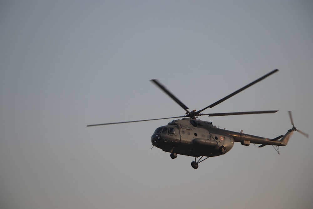 Un helicóptero militar volando a través de un cielo gris
