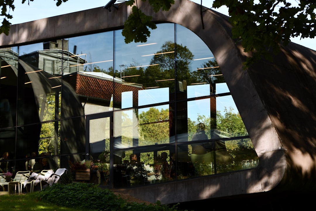 the reflection of a building in the windows of another building, A glass restaurant in a modern architecture building vi