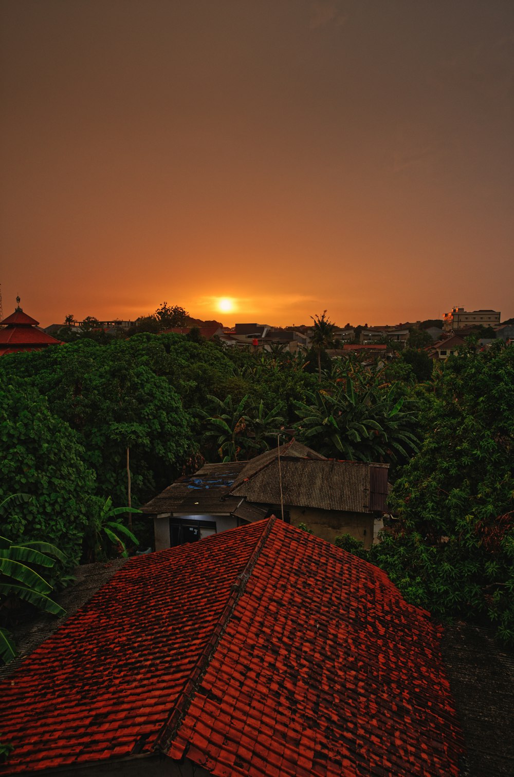 the sun is setting over a small village