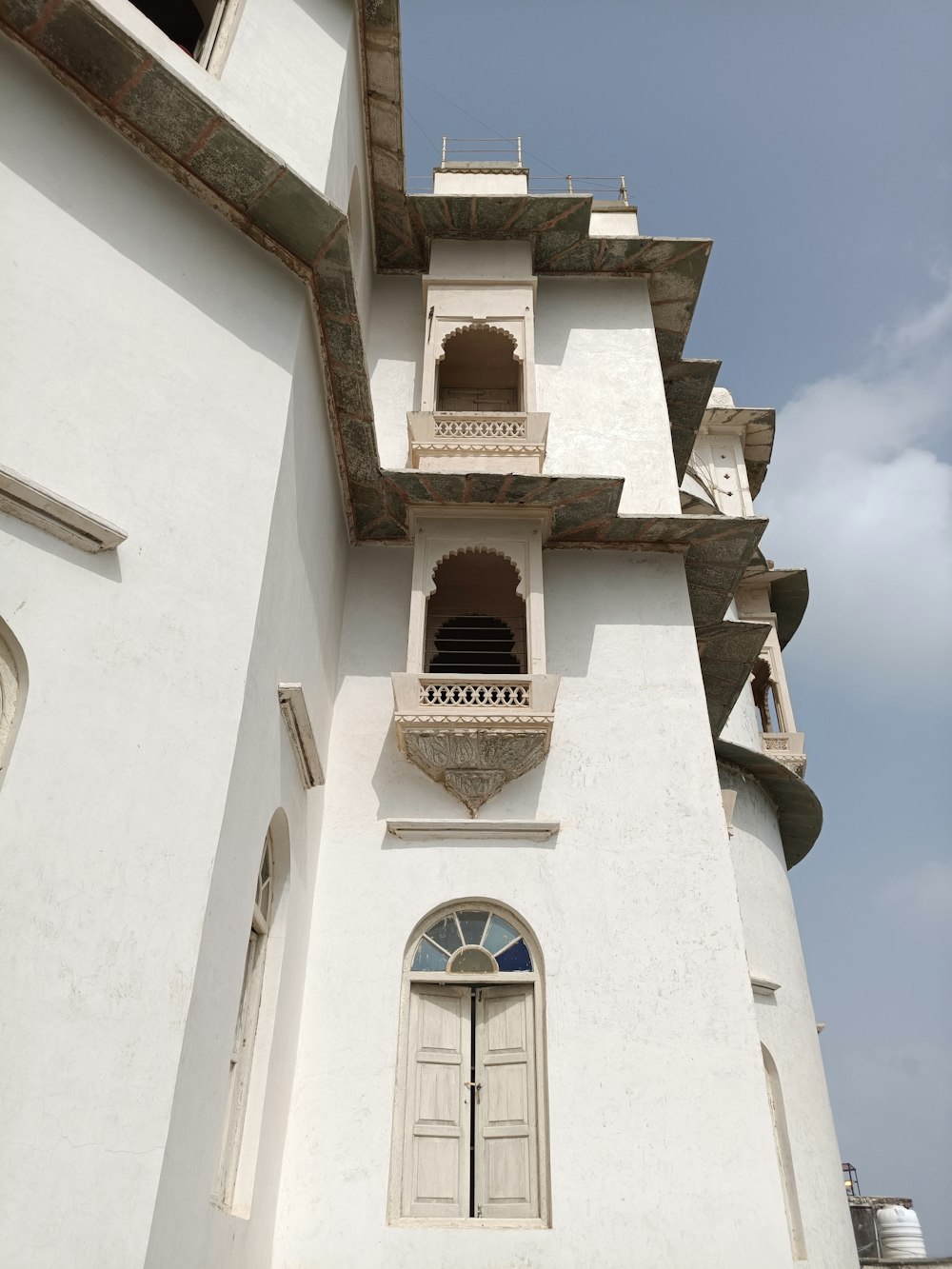 a tall white building with a clock on it's side