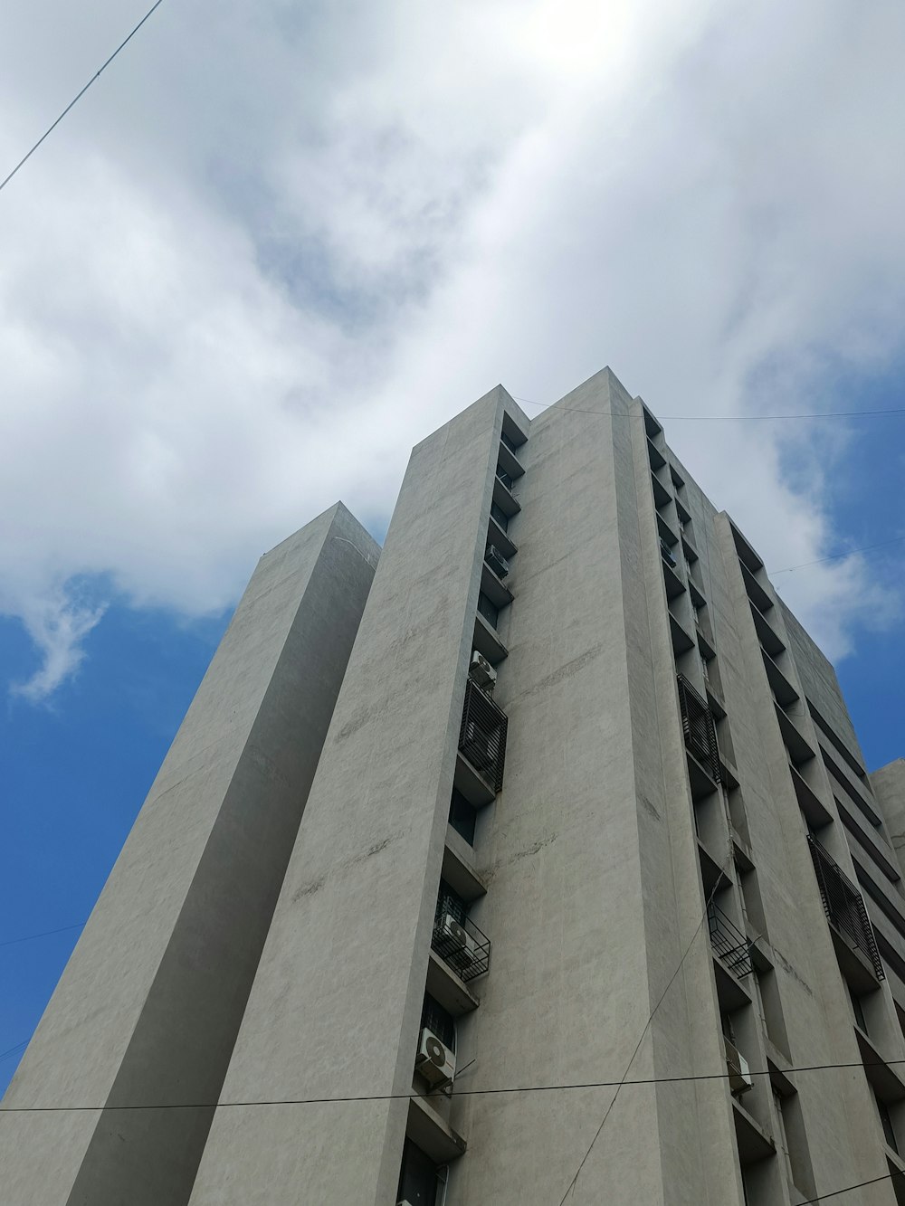 a tall concrete building with a sky background