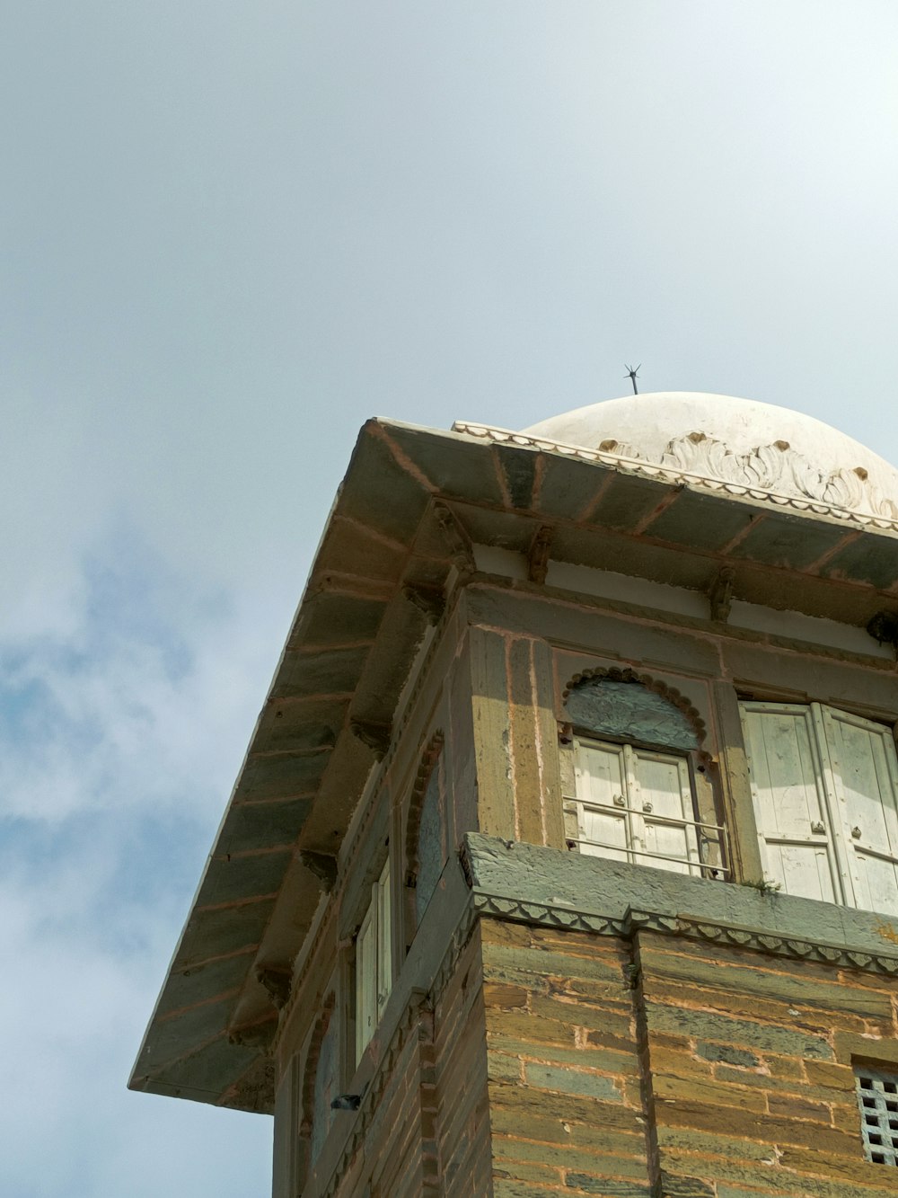 a tall brick building with a clock on the top of it